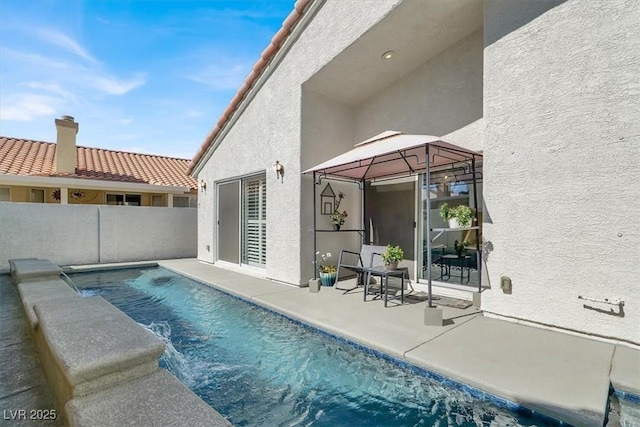 view of pool with fence, a patio, and a gazebo