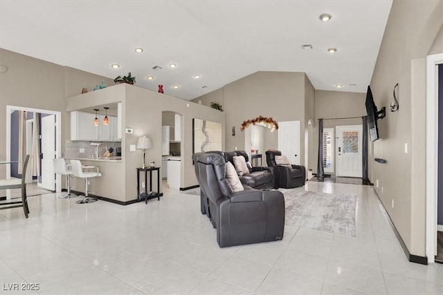 living room featuring arched walkways, high vaulted ceiling, light tile patterned flooring, visible vents, and baseboards