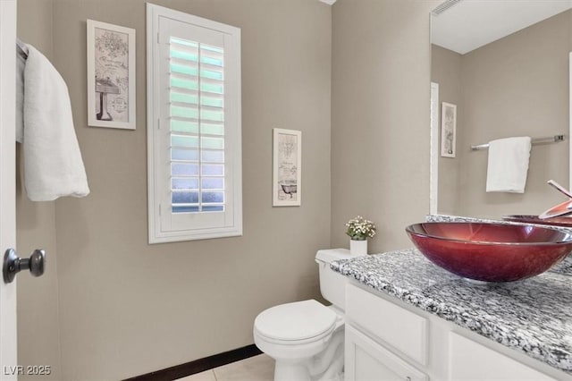 bathroom with toilet, tile patterned floors, and vanity