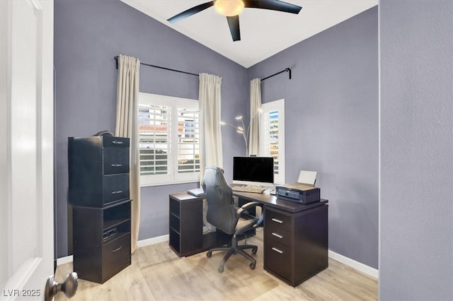 office area featuring vaulted ceiling, ceiling fan, light wood-style flooring, and baseboards