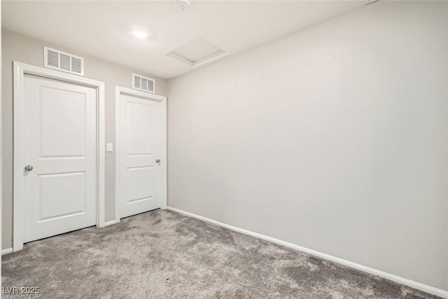 spare room with attic access, visible vents, light carpet, and baseboards