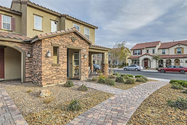 view of front of home with stone siding, a residential view, stucco siding, and a tiled roof