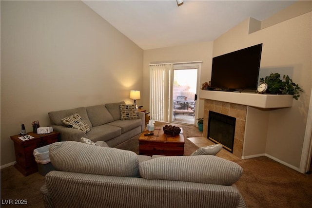 living area featuring carpet floors, a tile fireplace, vaulted ceiling, and baseboards