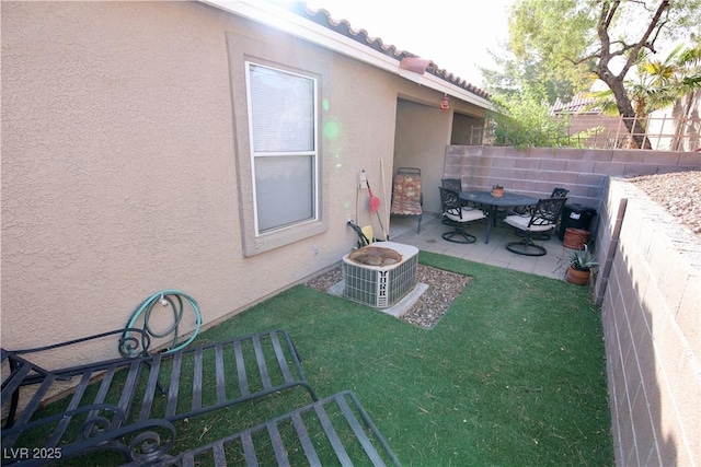 view of yard with a patio area, fence, and central air condition unit