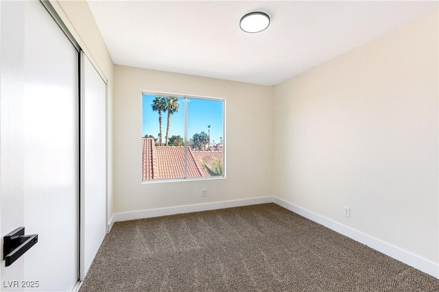 carpeted empty room with baseboards