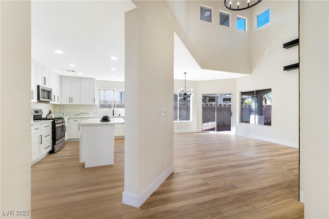 interior space with light wood-style flooring, baseboards, a notable chandelier, and recessed lighting