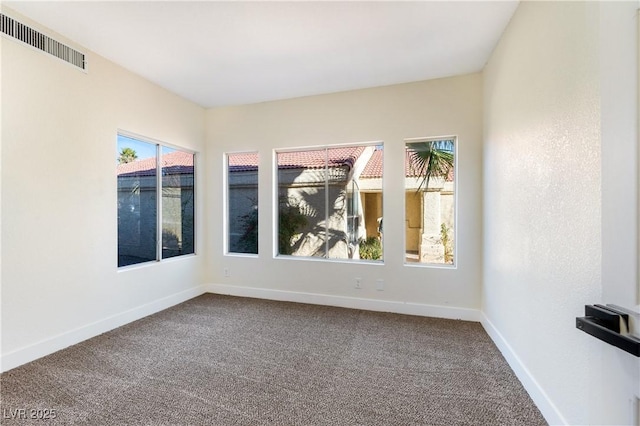 spare room with baseboards, visible vents, and carpet flooring