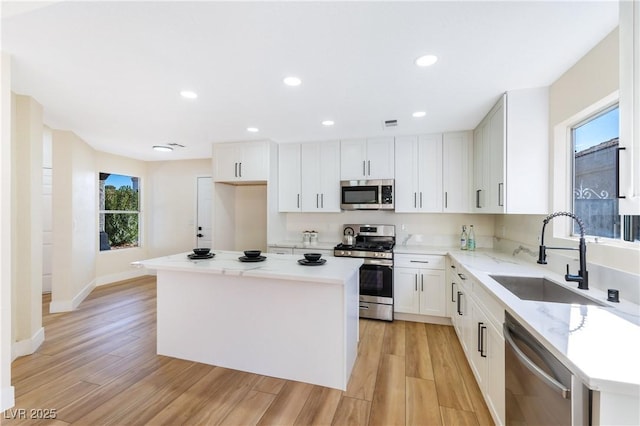 kitchen with stainless steel appliances, a center island, and a sink