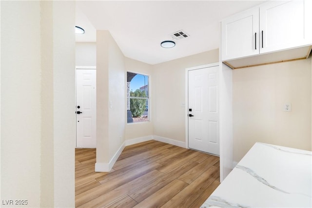 bedroom with baseboards, visible vents, and light wood-style floors