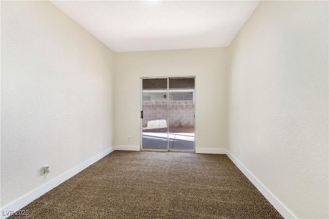 carpeted spare room with a textured wall and baseboards