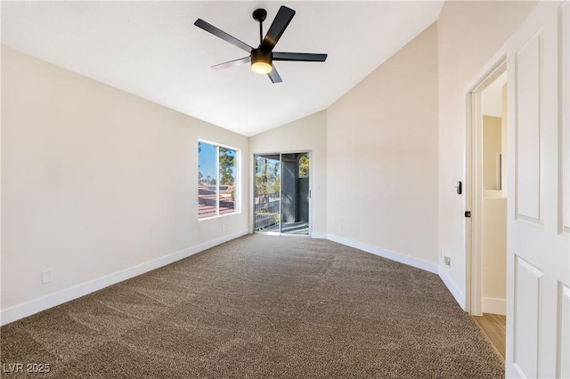 carpeted spare room featuring vaulted ceiling, baseboards, and ceiling fan