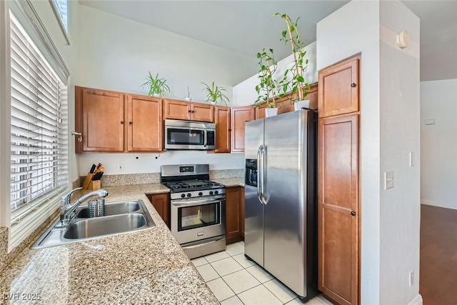 kitchen featuring light tile patterned floors, stainless steel appliances, light countertops, a towering ceiling, and a sink