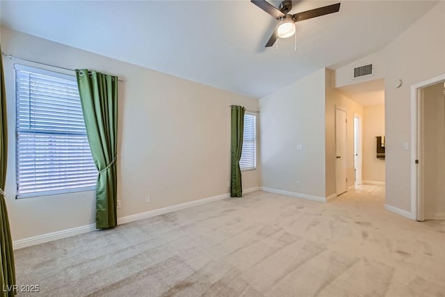 carpeted empty room featuring lofted ceiling, a healthy amount of sunlight, baseboards, and a ceiling fan