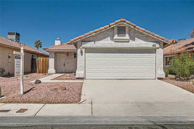 view of front of house with a chimney, stucco siding, concrete driveway, a garage, and a tiled roof