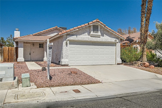 view of front of house featuring driveway, a garage, a chimney, a tiled roof, and stucco siding