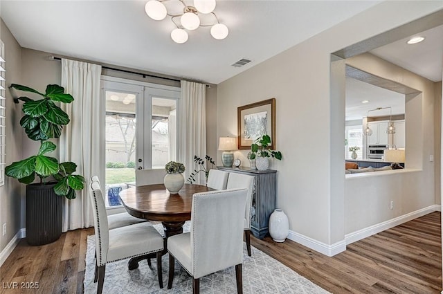 dining room featuring baseboards, visible vents, wood finished floors, and french doors