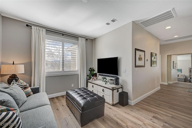 living room featuring light wood finished floors, baseboards, visible vents, and recessed lighting