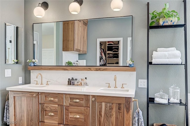 full bathroom featuring tasteful backsplash, a sink, a spacious closet, and double vanity