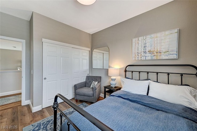 bedroom featuring a closet, baseboards, and wood finished floors