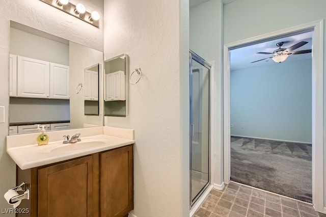 bathroom with a shower stall, vanity, and a ceiling fan