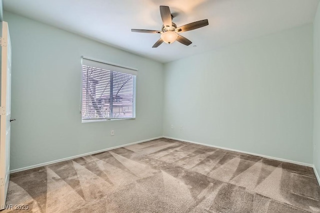 carpeted empty room featuring ceiling fan and baseboards