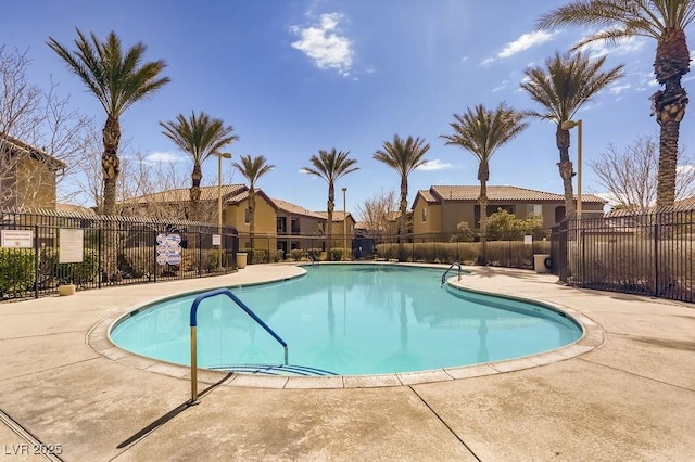 community pool featuring a patio area, a residential view, and fence