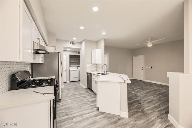 kitchen with white cabinetry, a sink, and gas range oven