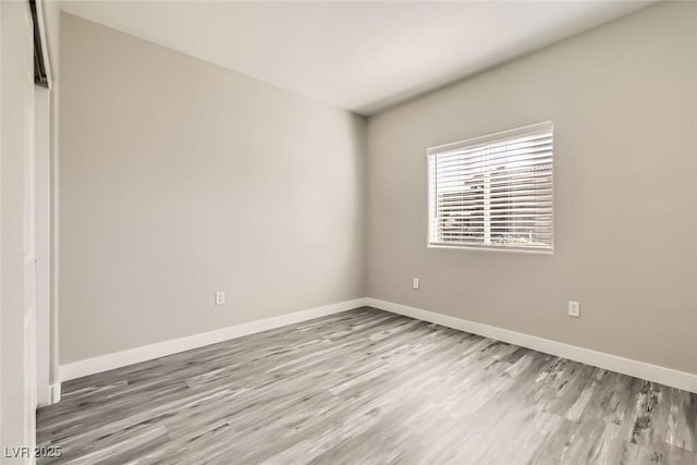 empty room featuring wood finished floors and baseboards