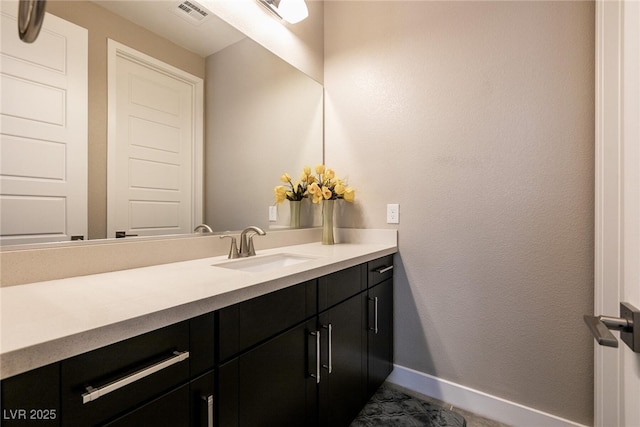 bathroom featuring visible vents, vanity, and baseboards