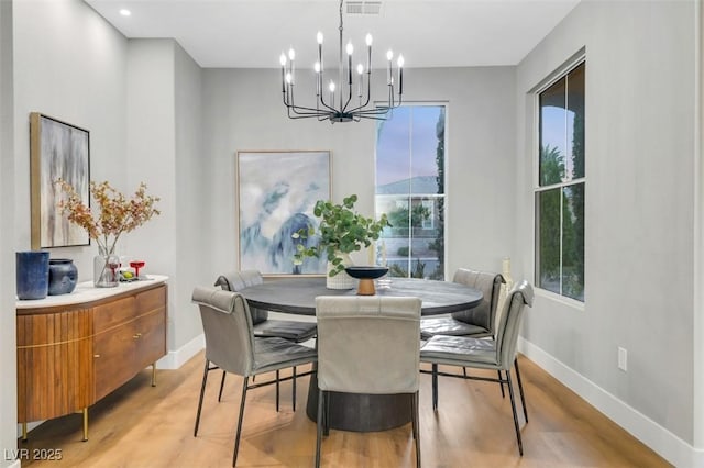 dining area featuring light wood-style floors, baseboards, and visible vents