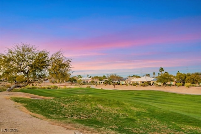 surrounding community featuring view of golf course and a lawn