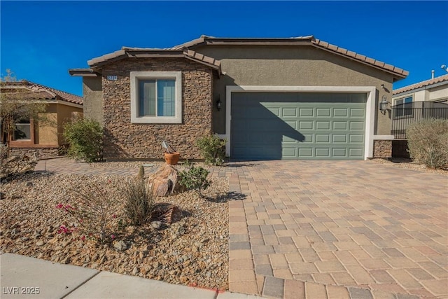 single story home with a garage, a tile roof, stone siding, decorative driveway, and stucco siding