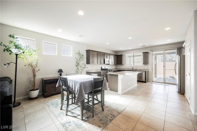 dining space featuring light tile patterned floors, baseboards, and recessed lighting