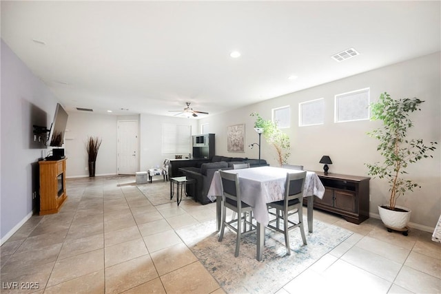 dining space with light tile patterned floors, ceiling fan, visible vents, and baseboards