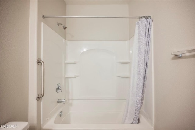 full bathroom with toilet and a shower with shower curtain