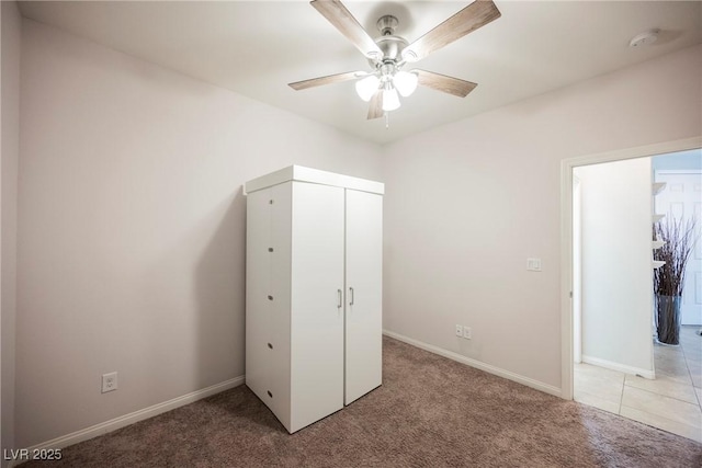 unfurnished bedroom with a closet, light colored carpet, and baseboards