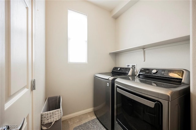 washroom featuring laundry area, washing machine and dryer, and baseboards