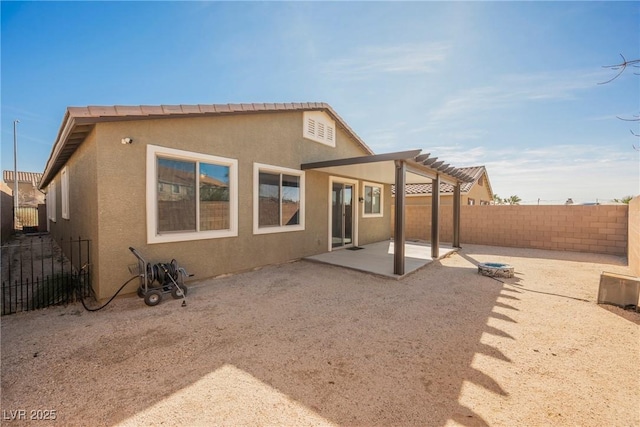 rear view of house with stucco siding, an outdoor fire pit, a patio area, a pergola, and a fenced backyard