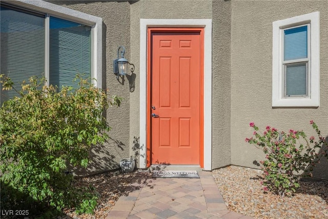 property entrance with stucco siding