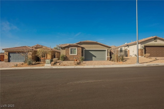 view of front facade with a garage, a tile roof, decorative driveway, and stucco siding