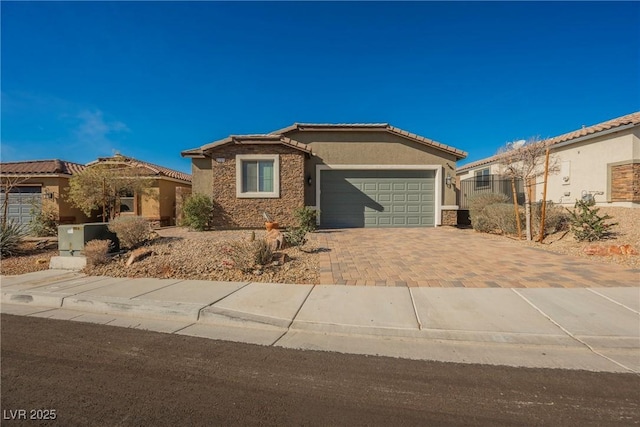 view of front facade with a garage, stone siding, a tiled roof, decorative driveway, and stucco siding