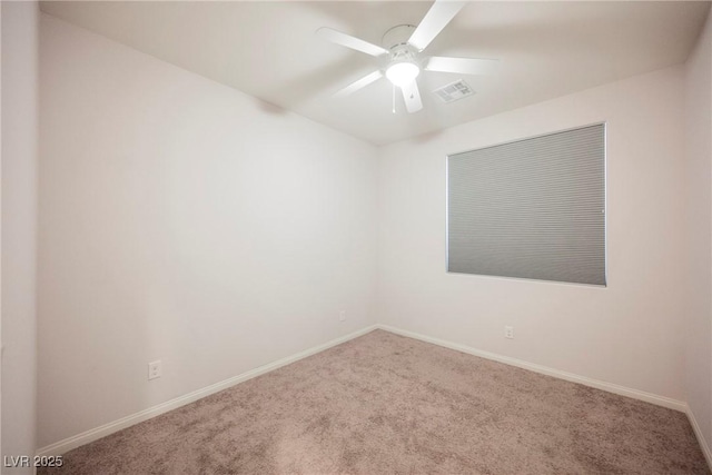 spare room featuring ceiling fan, carpet flooring, visible vents, and baseboards