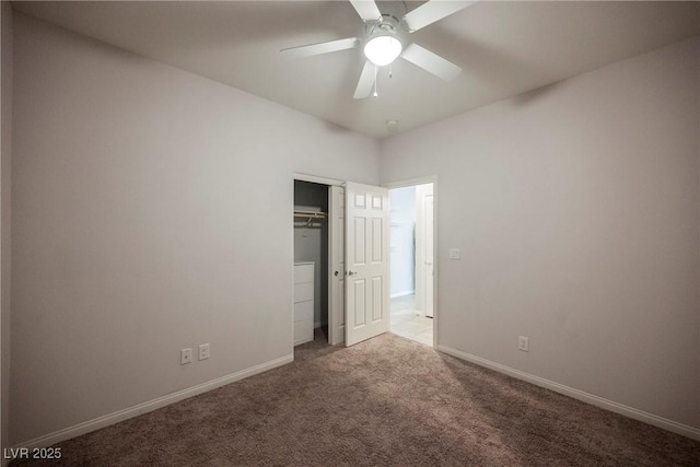 carpeted spare room featuring baseboards and a ceiling fan