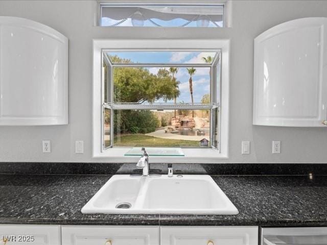 kitchen with white cabinetry, a sink, and stainless steel dishwasher