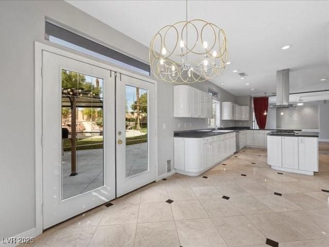 kitchen with dark countertops, island exhaust hood, white cabinetry, and french doors