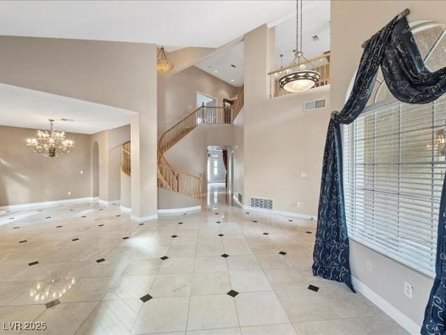 tiled foyer with baseboards, stairway, visible vents, and a notable chandelier