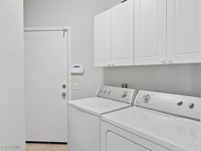 laundry area featuring light tile patterned floors, washing machine and dryer, and cabinet space