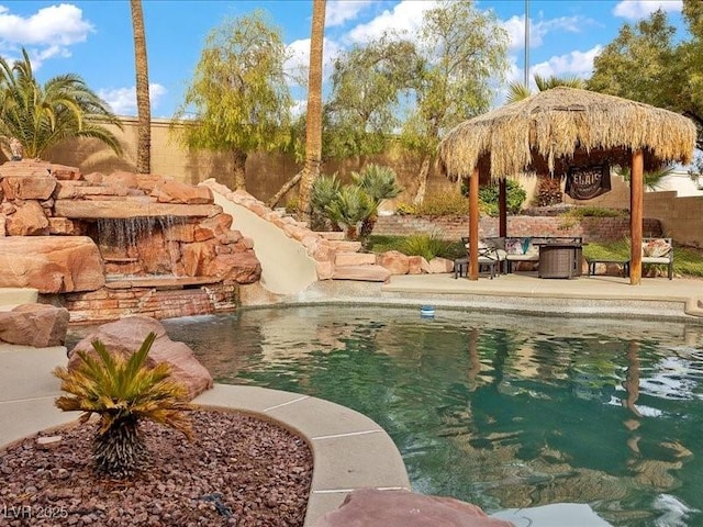 view of swimming pool with a patio area, a fenced backyard, a fenced in pool, and a gazebo