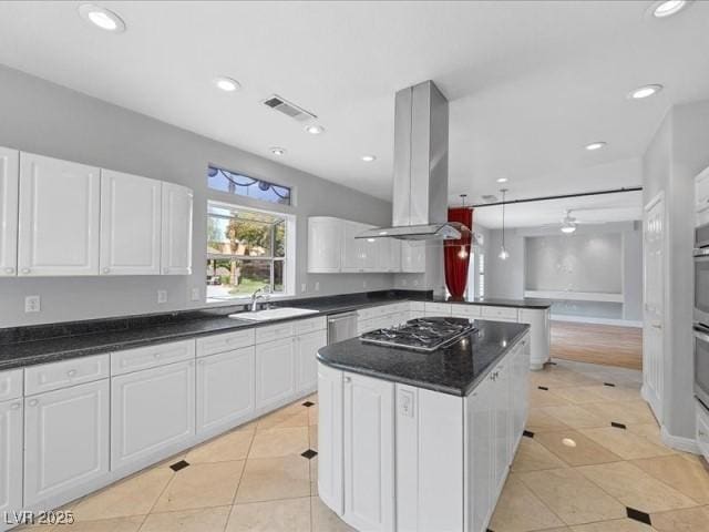 kitchen with a sink, stainless steel appliances, island exhaust hood, and white cabinetry