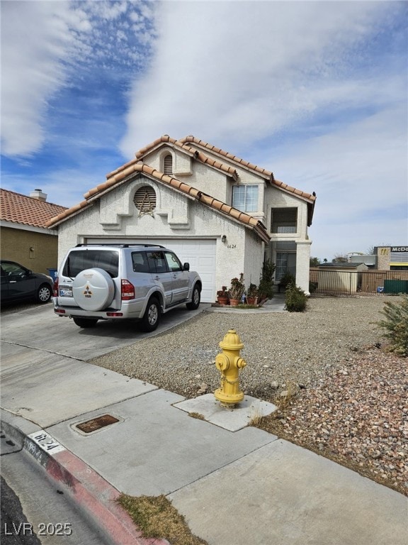 view of front of home featuring a garage, concrete driveway, a tiled roof, and stucco siding